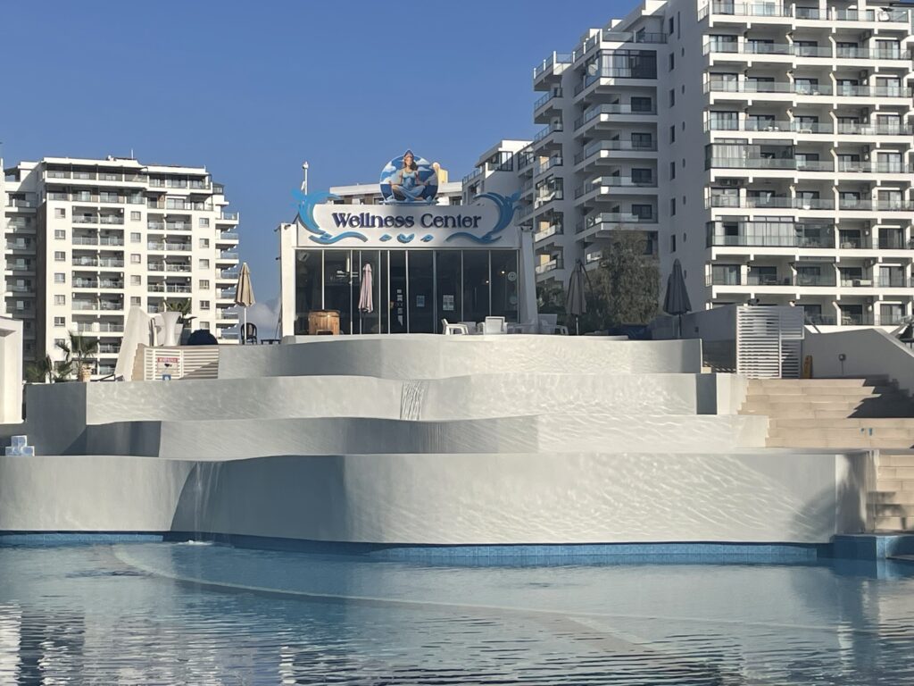 Wellness Center mit Wasserlandschaft und mehreren Gebäuden im Hintergrund.