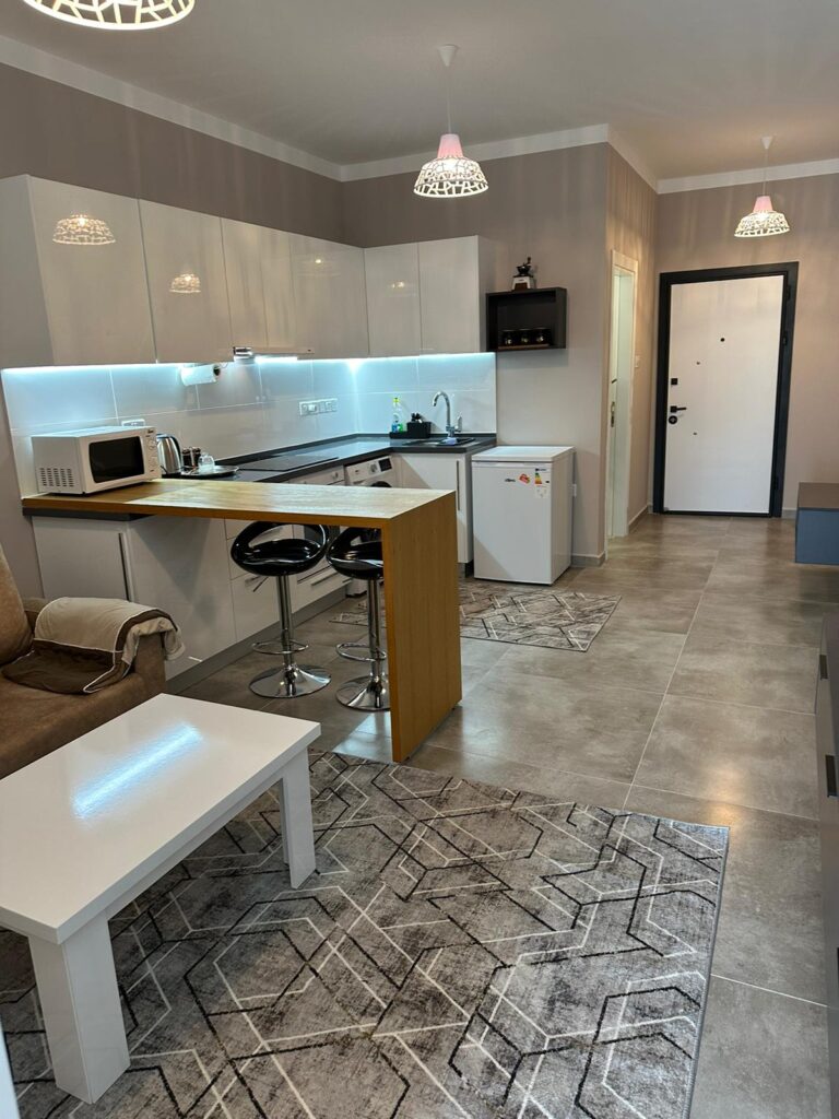 Modern eingerichtete Küche mit Barbereich, Kühlschrank und gemütlicher Sitzecke.