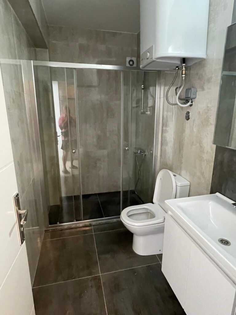 Modernes Badezimmer mit Dusche, Toilette und Waschbecken.